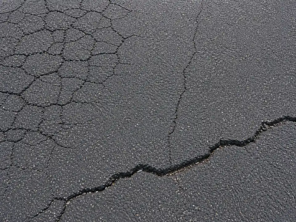 Close-up of block, hairline, and transverse cracks in asphalt